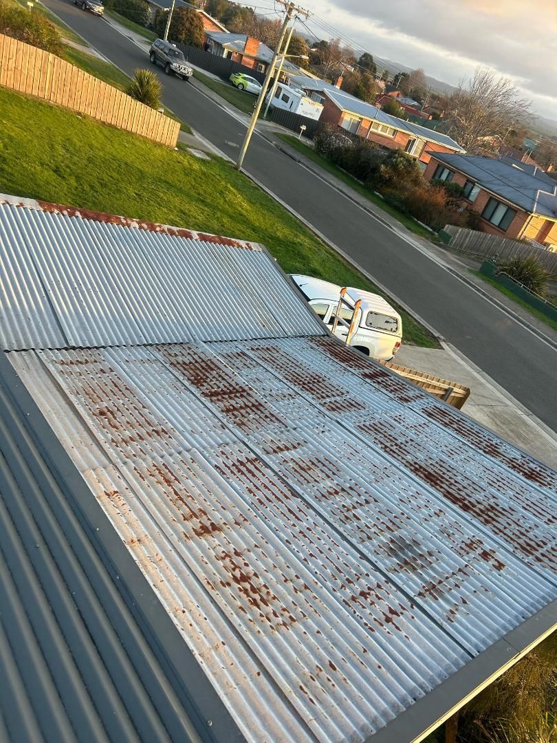 An aerial view of a rusty metal roof that needs to be repaired