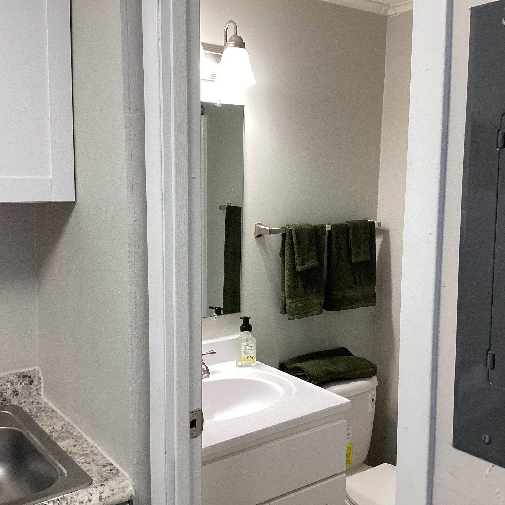 Bathroom interior with sink, toilet, mirror, and towels, in a small space.