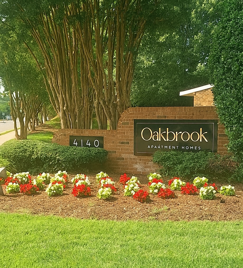 Oakbrook apartment complex sign with flower bed in front.
