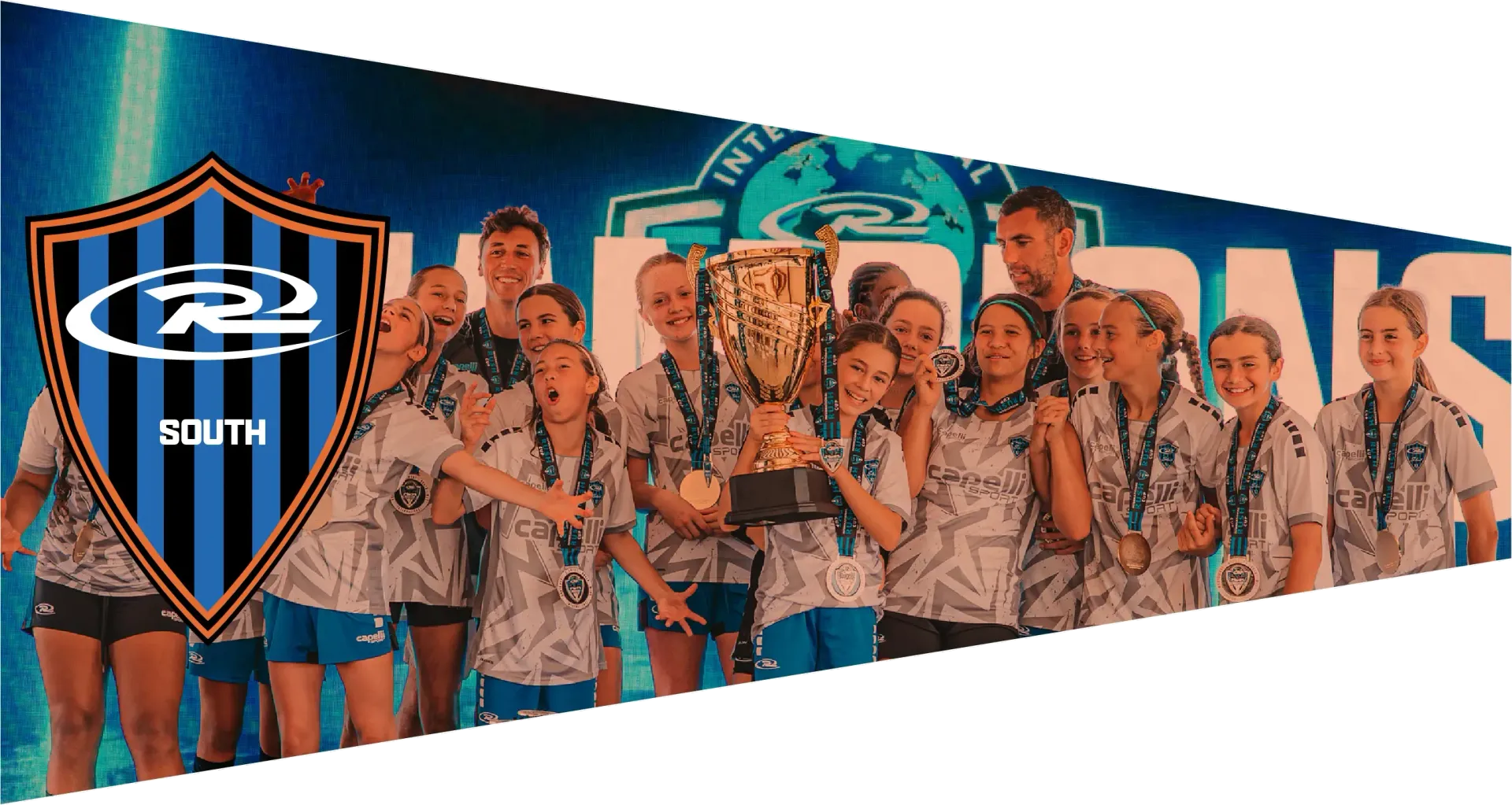 Cheer team holding trophies, wearing matching shirts, celebrating on a stage with a banner reading