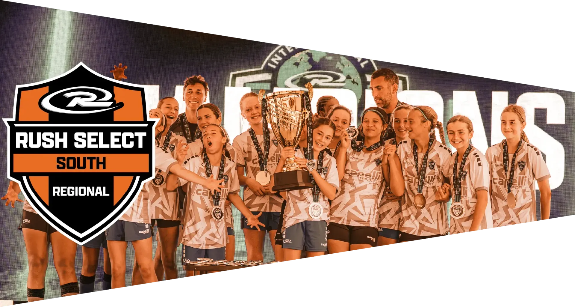 Cheer team holding trophies, wearing matching shirts, celebrating on a stage with a banner reading 