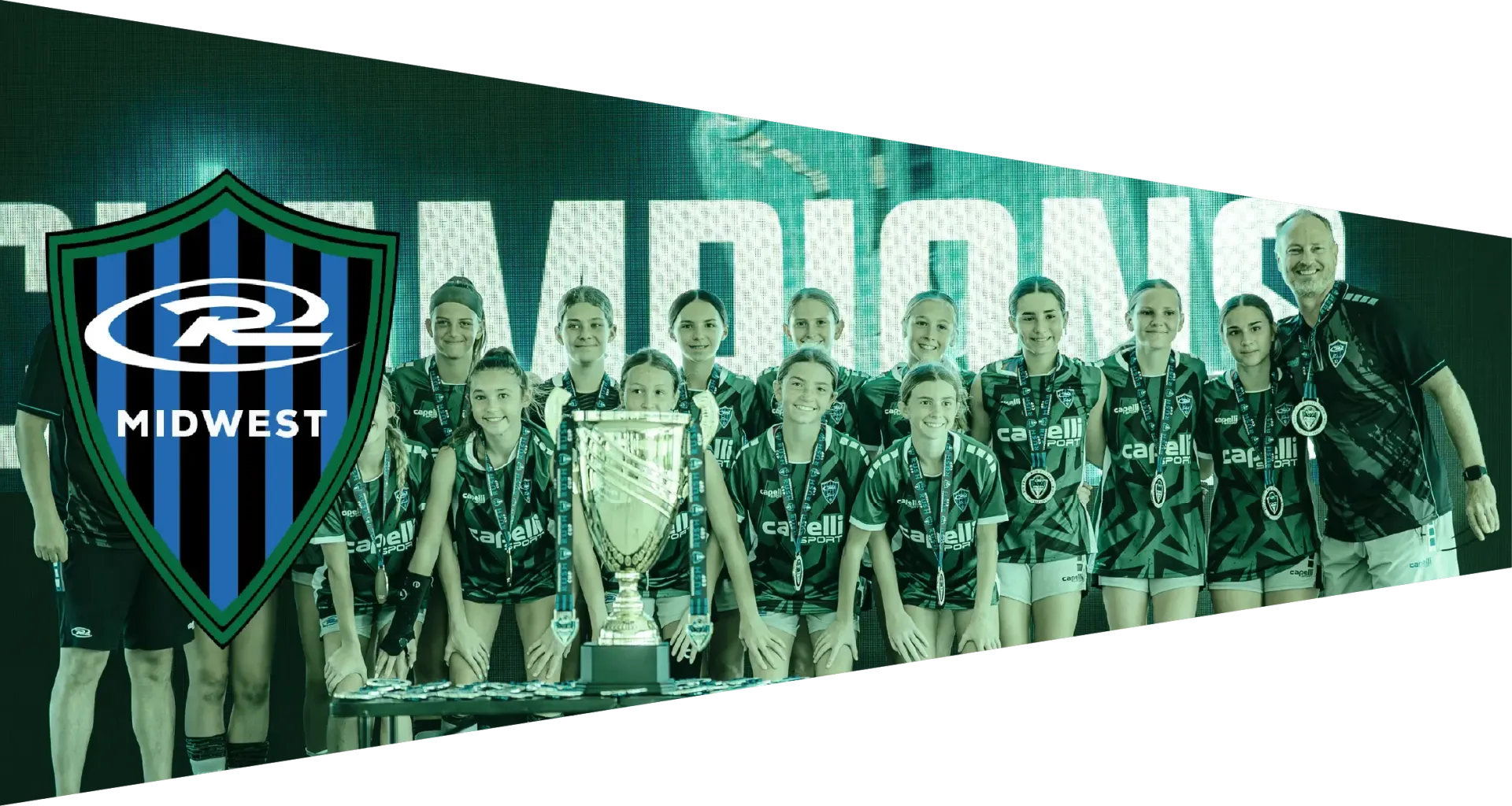 A team of young athletes with medals pose, holding a trophy and banner that reads Champions. Logo is the R2 Midwest.