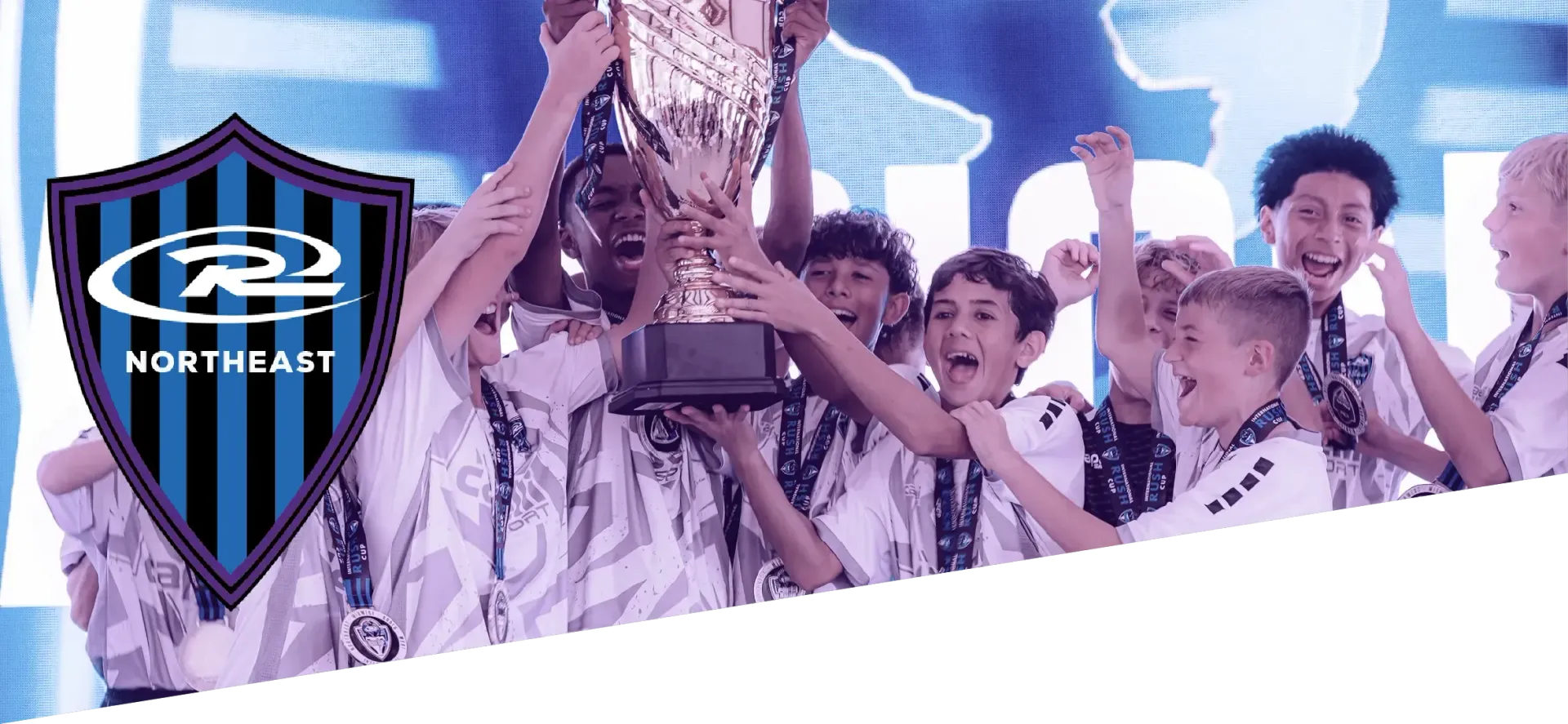 Children holding a trophy, celebrating. The Rush Select Northeast logo is on the left.