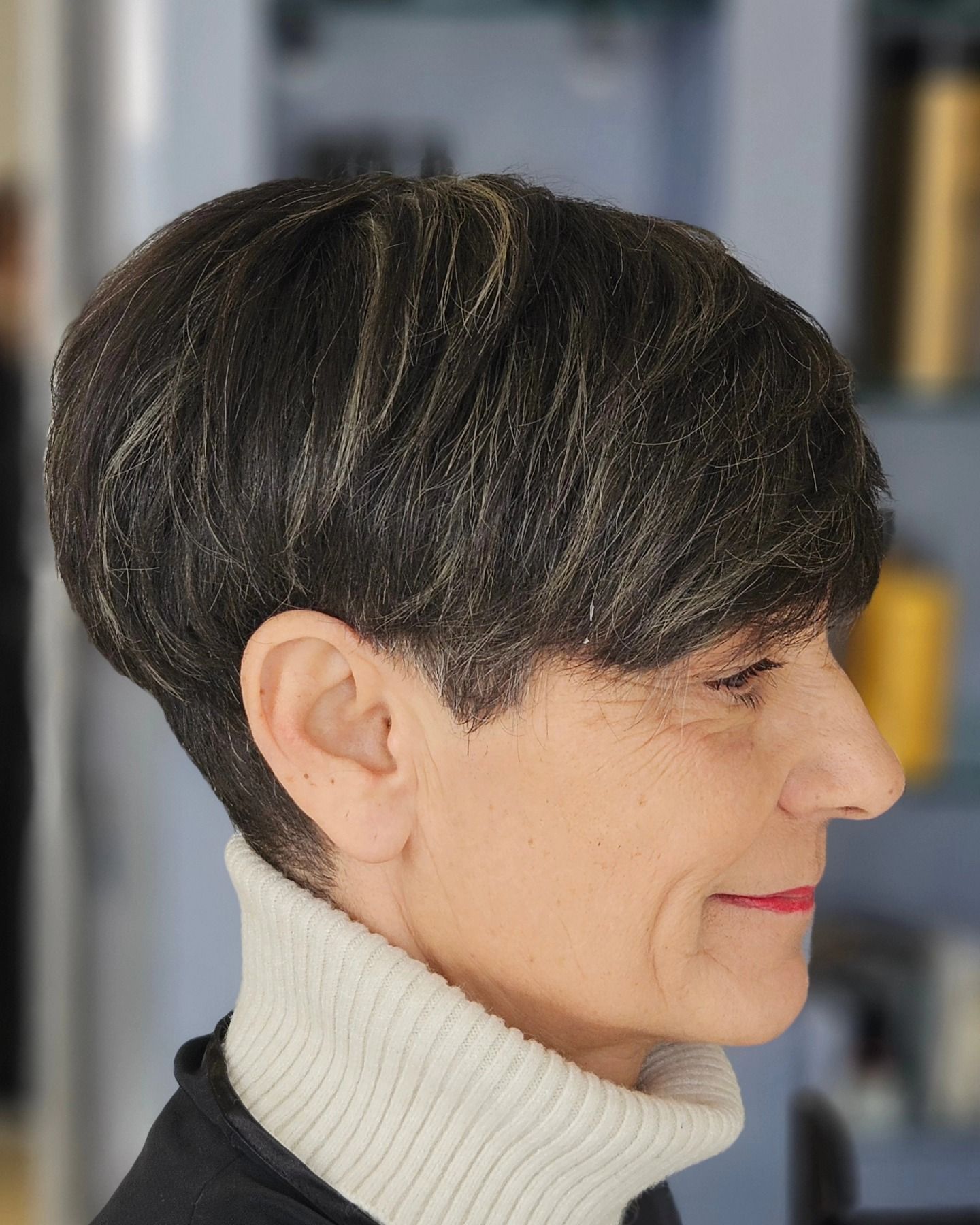 Una donna con i capelli corti indossa un dolcevita bianco