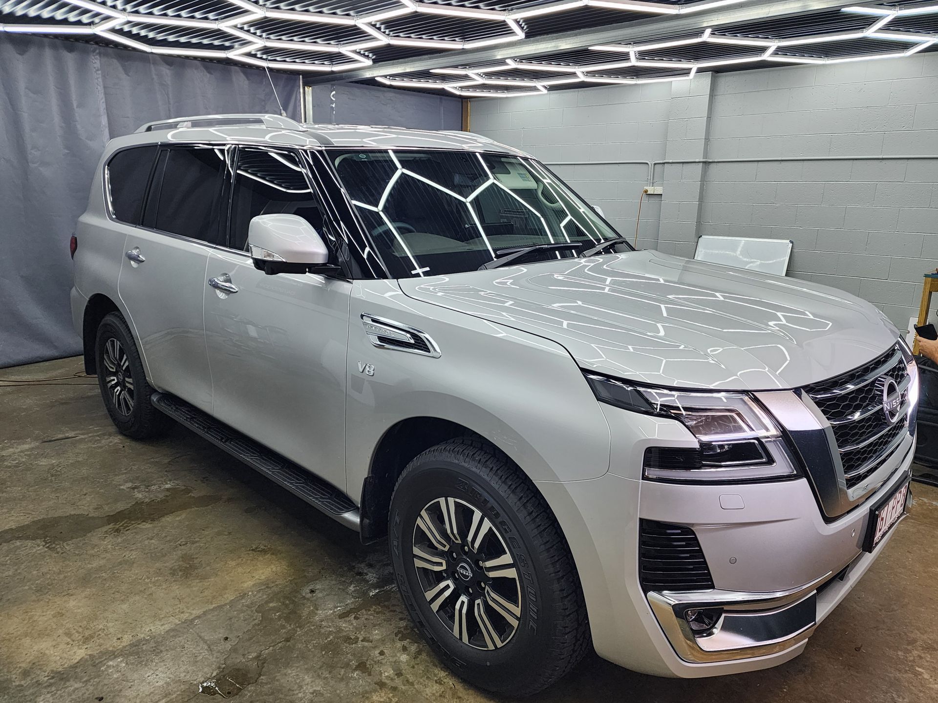 A Black Nissan Patrol Suv Parked Indoors — Superior Window Tinting & Whitewalls in Portsmith, QLD