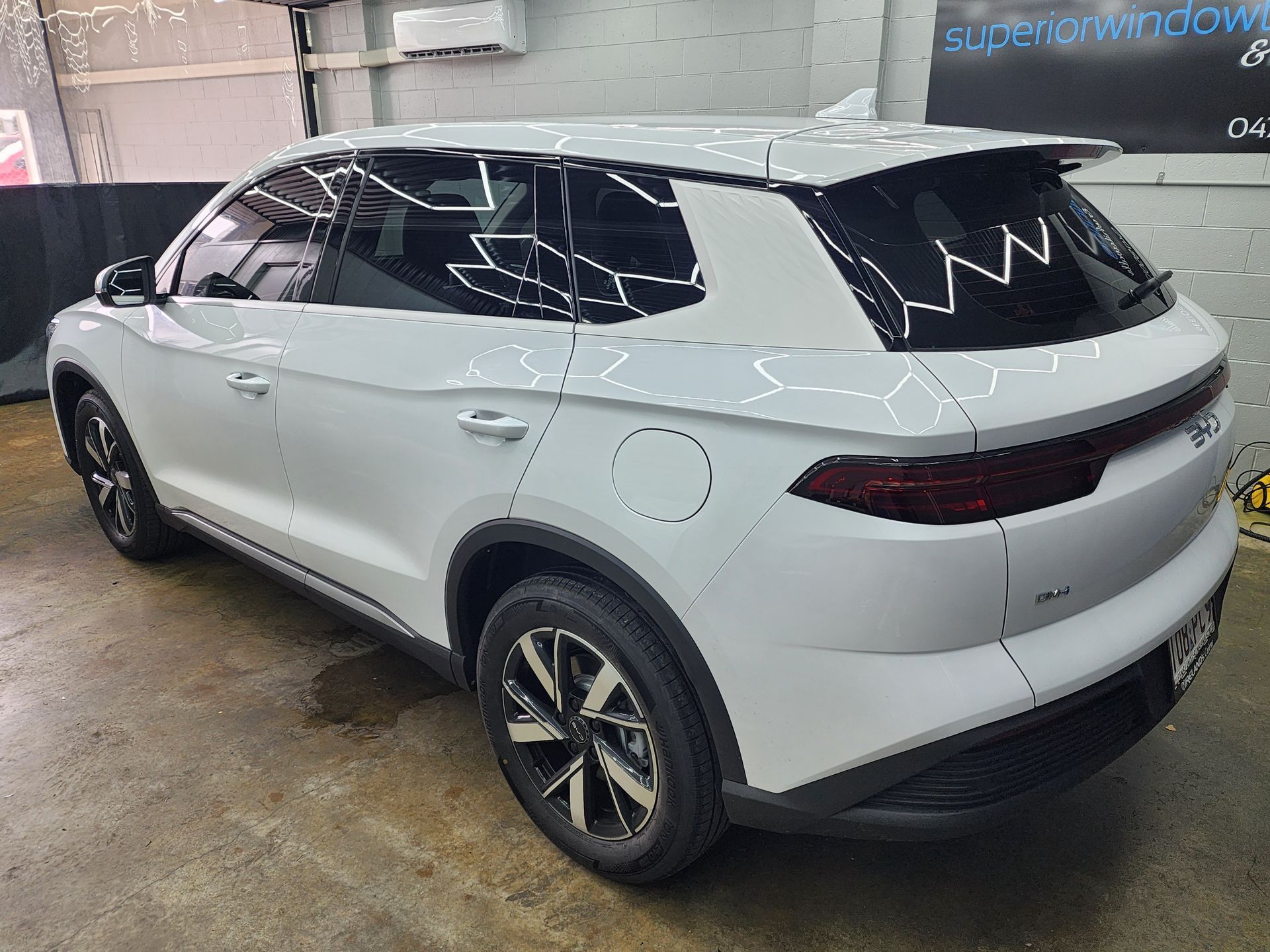 A Dark Gray Pickup Truck With a Bed Canopy Parked in a Garage — Superior Window Tinting & Whitewalls in Portsmith, QLD