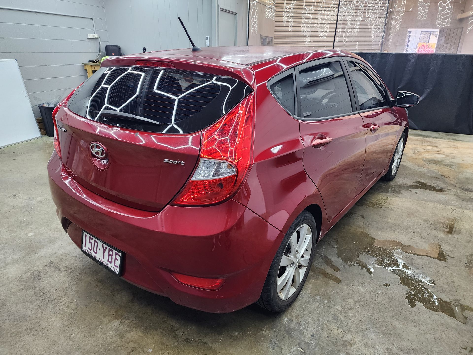 A Red Car Exterior, Focusing on the Dark Tinted Window — Superior Window Tinting & Whitewalls in Portsmith, QLD