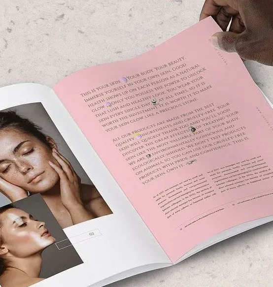 An open magazine spread features text on a pink background next to photos of a person touching their face.