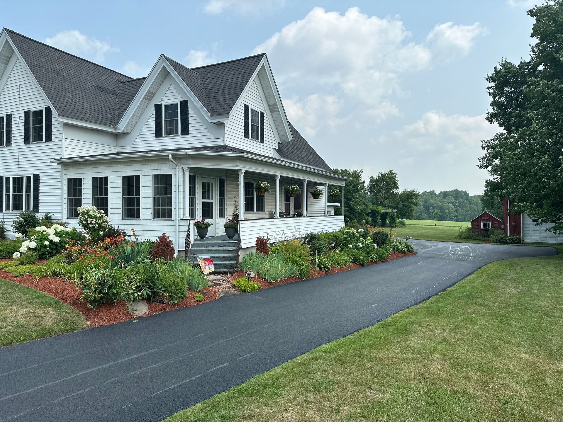 A large white house with a porch and a driveway