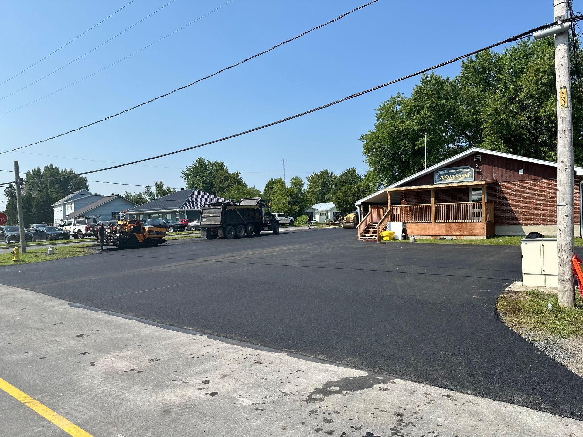 A truck is driving down a road next to a house.