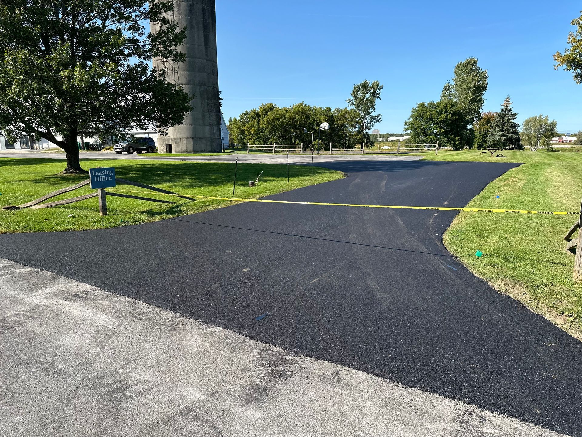 A newly paved driveway with a water tower in the background