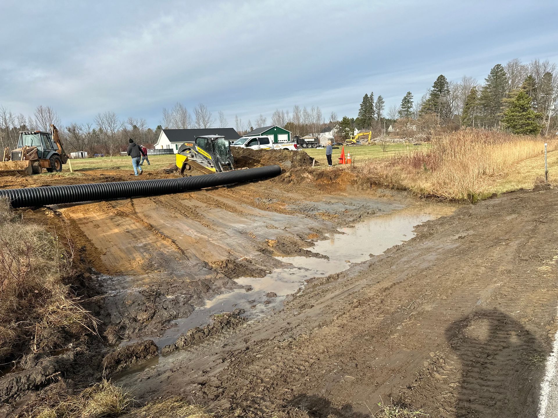 A group of people are working on a muddy road.