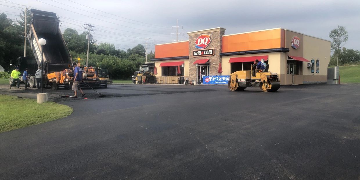 A driveway is being paved in front of a fast food restaurant.