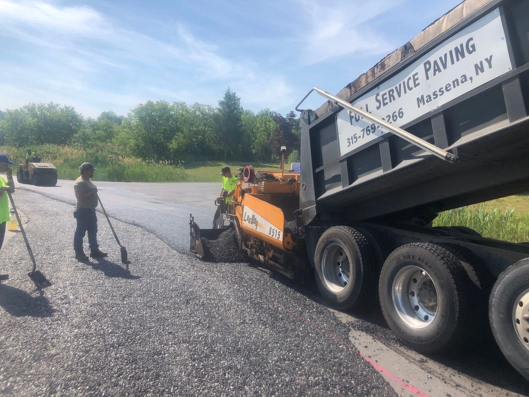A dump truck is sitting on the side of a road.