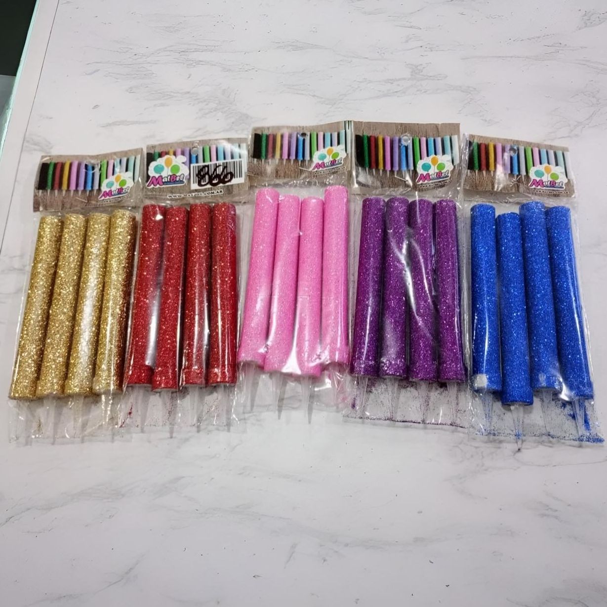 Un montón de velas de cumpleaños están alineadas en una mesa.