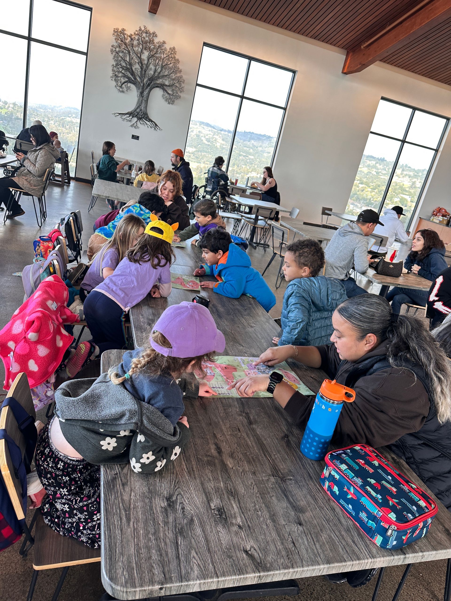 A group of Montessori child are sitting at tables in a restaurant at the Oakland Zoo.
