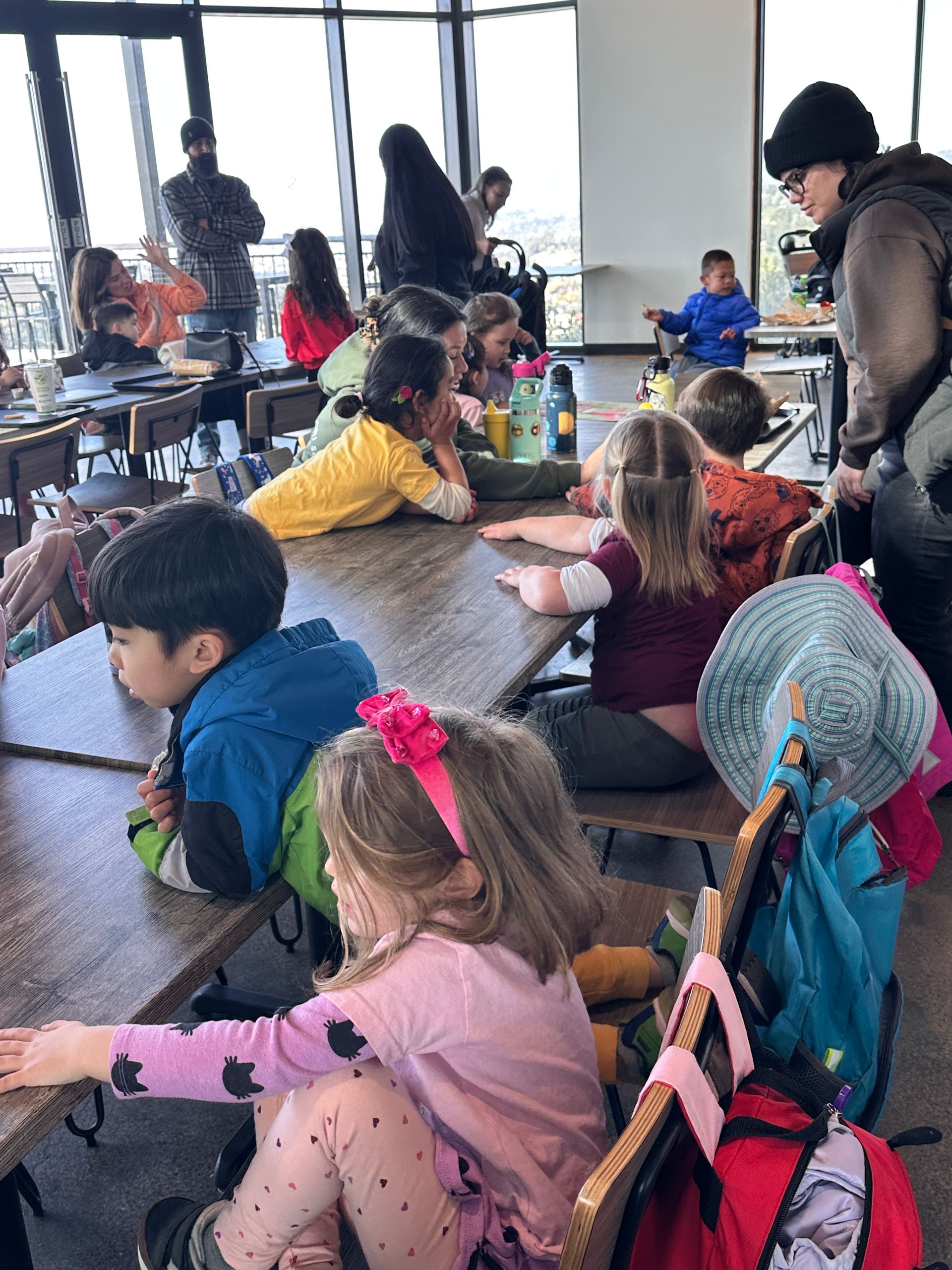 A group of Montessori child are sitting at tables in a restaurant at the Oakland Zoo.