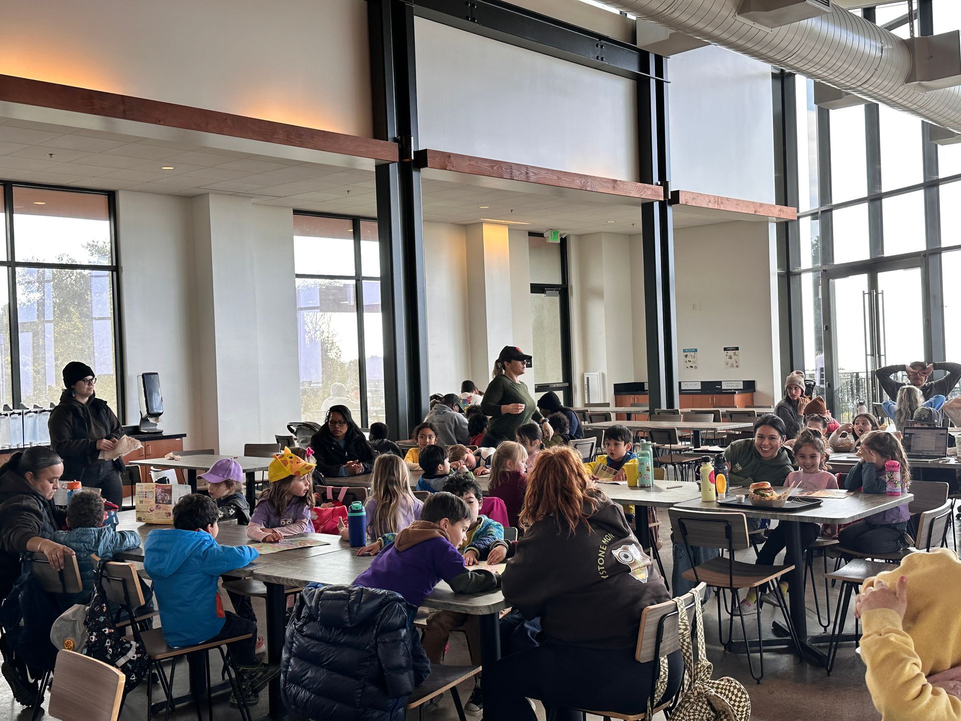 A group of Montessori child are sitting at tables in a restaurant at the Oakland Zoo.