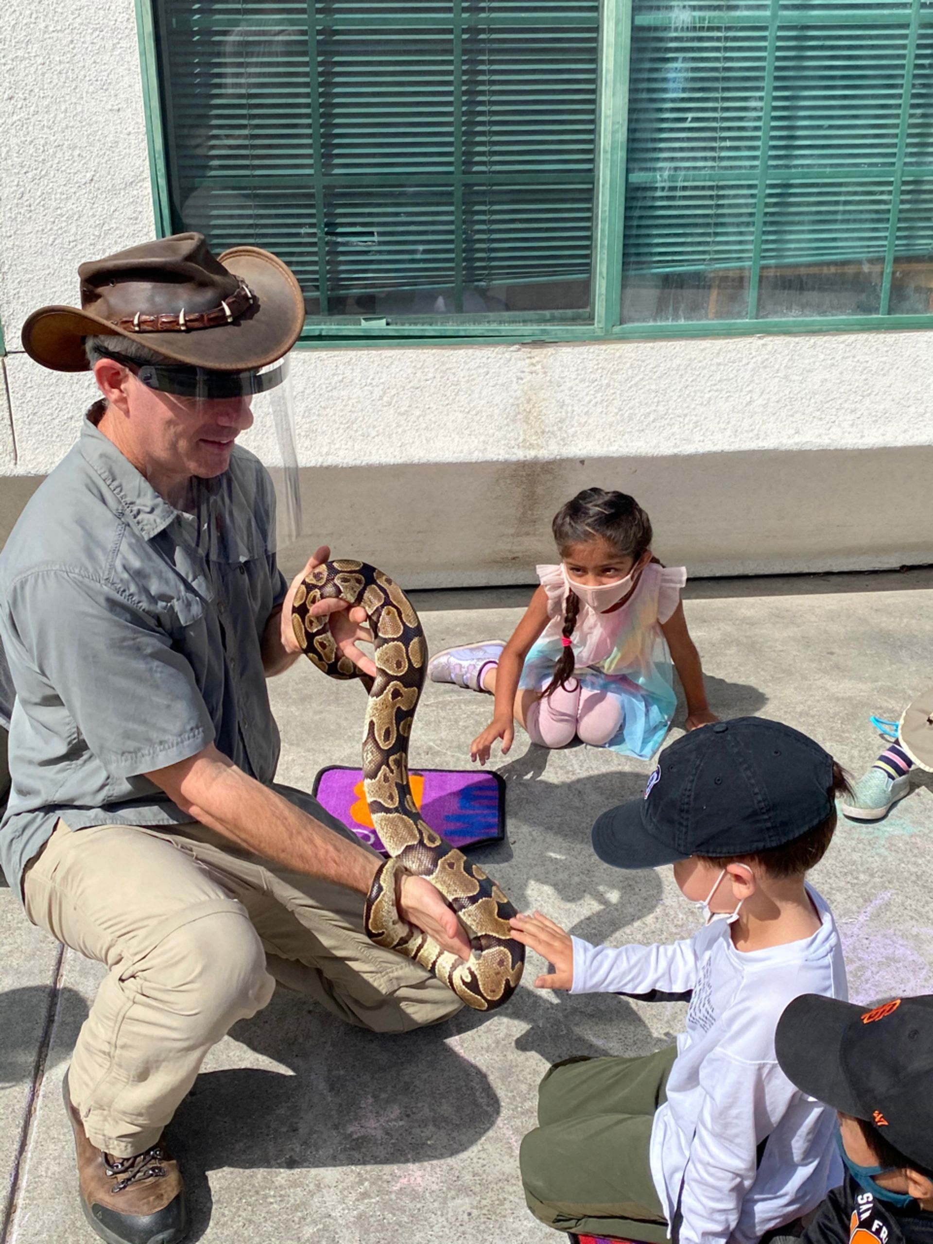 montessori children and guide holding a snake
