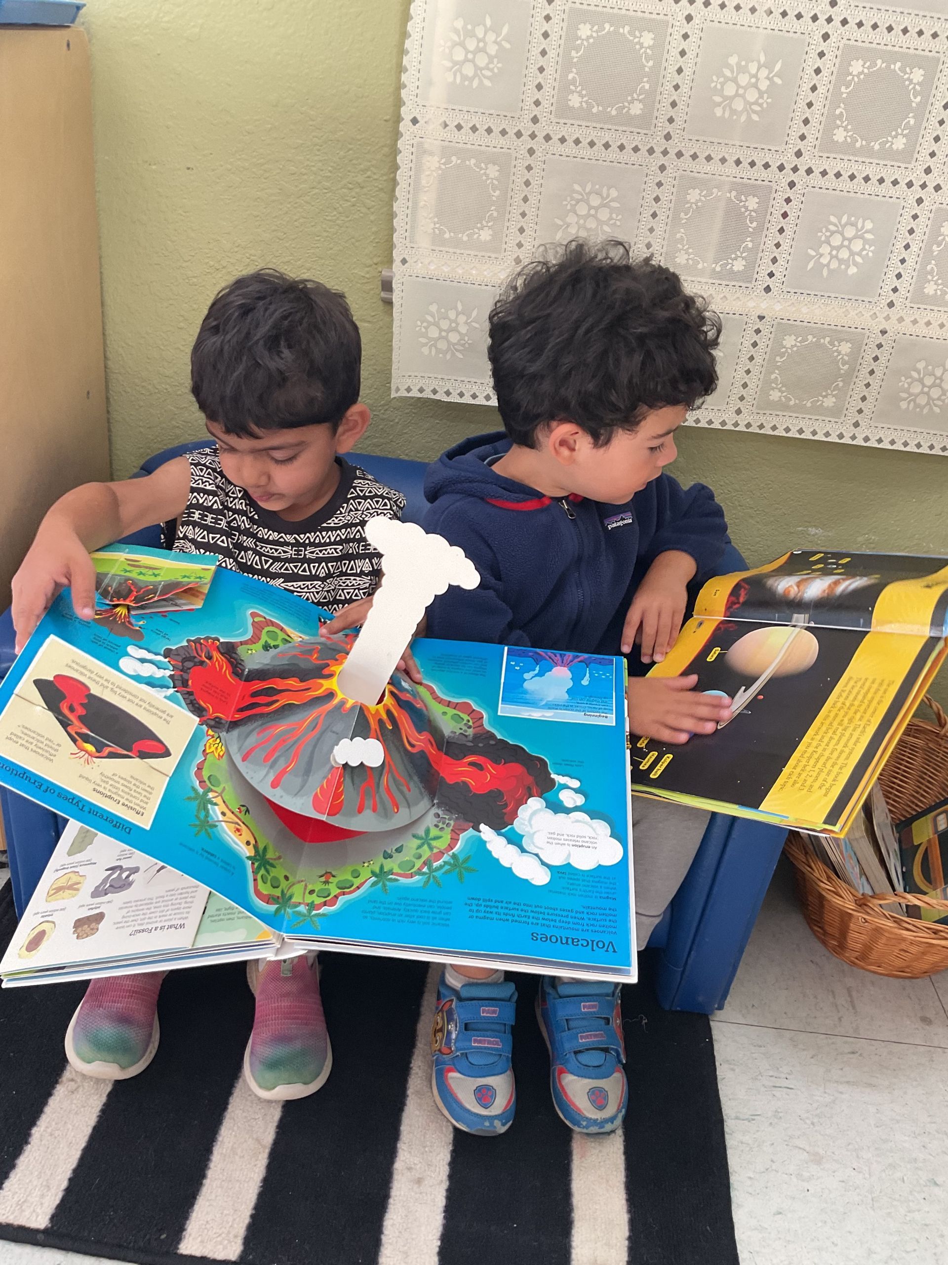 montessori primary student reading a book about volcanos