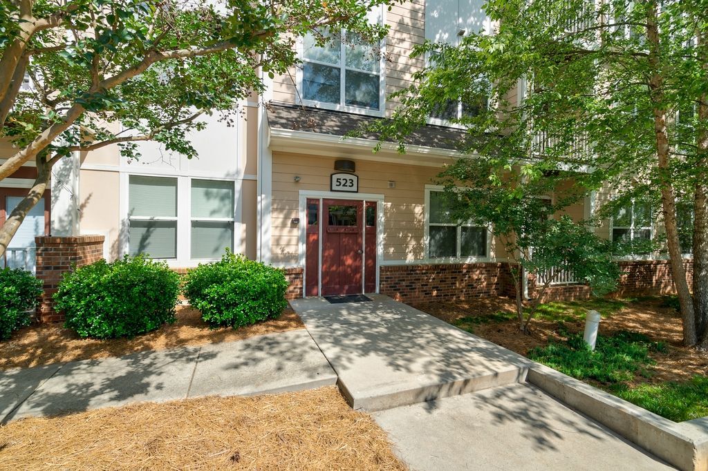 Exterior view of an apartment building entrance with landscaping.