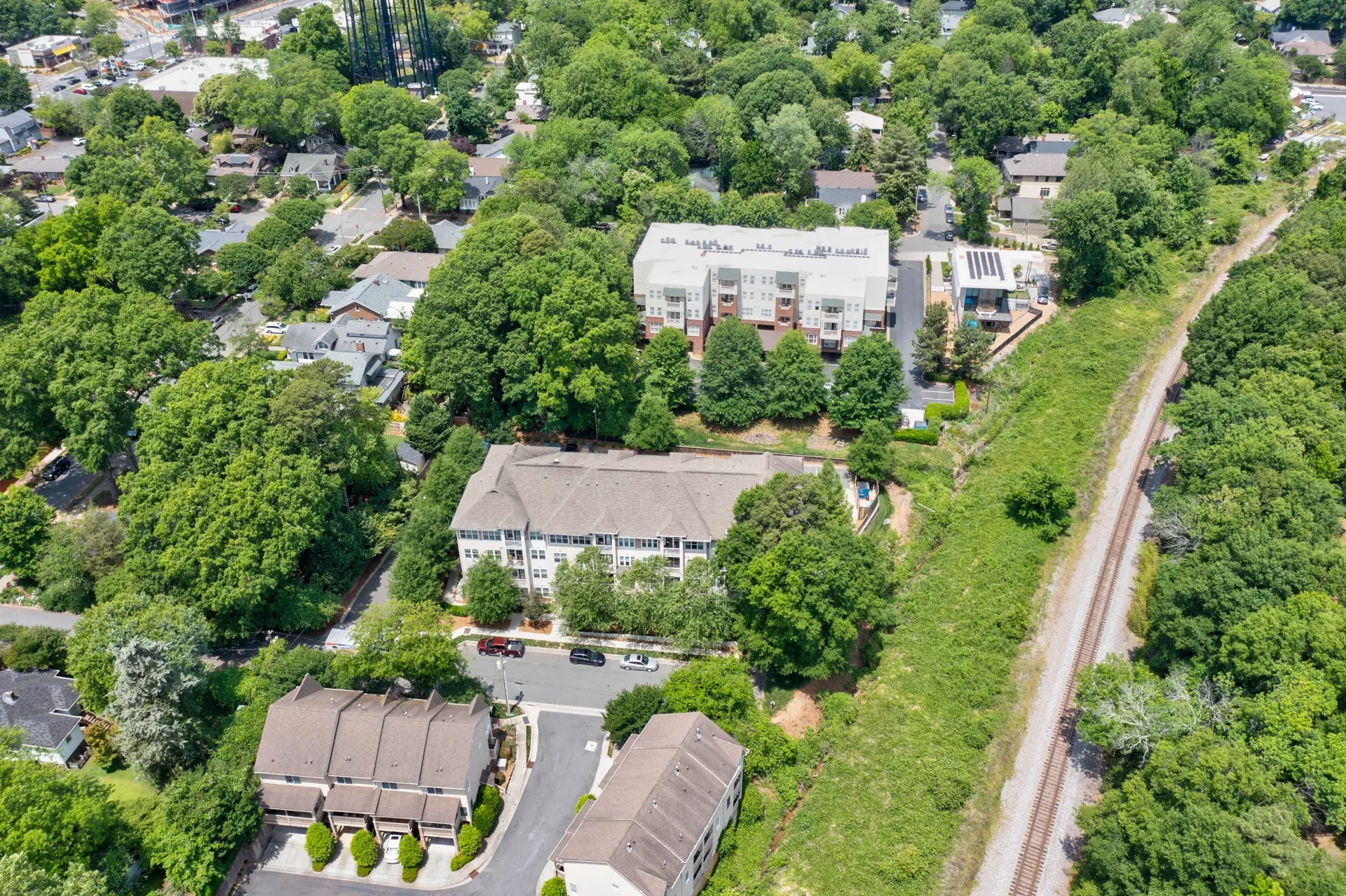 Aerial view of residential community featuring buildings surrounded by greenery