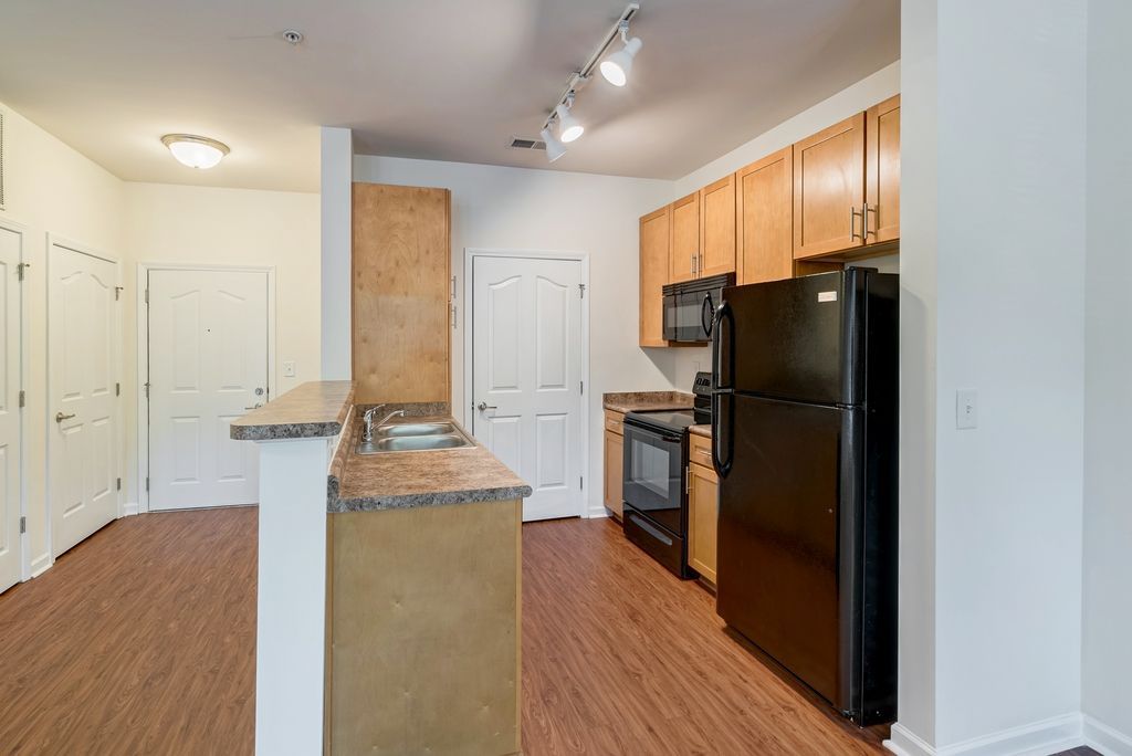 Modern kitchen with wooden cabinets and black appliances