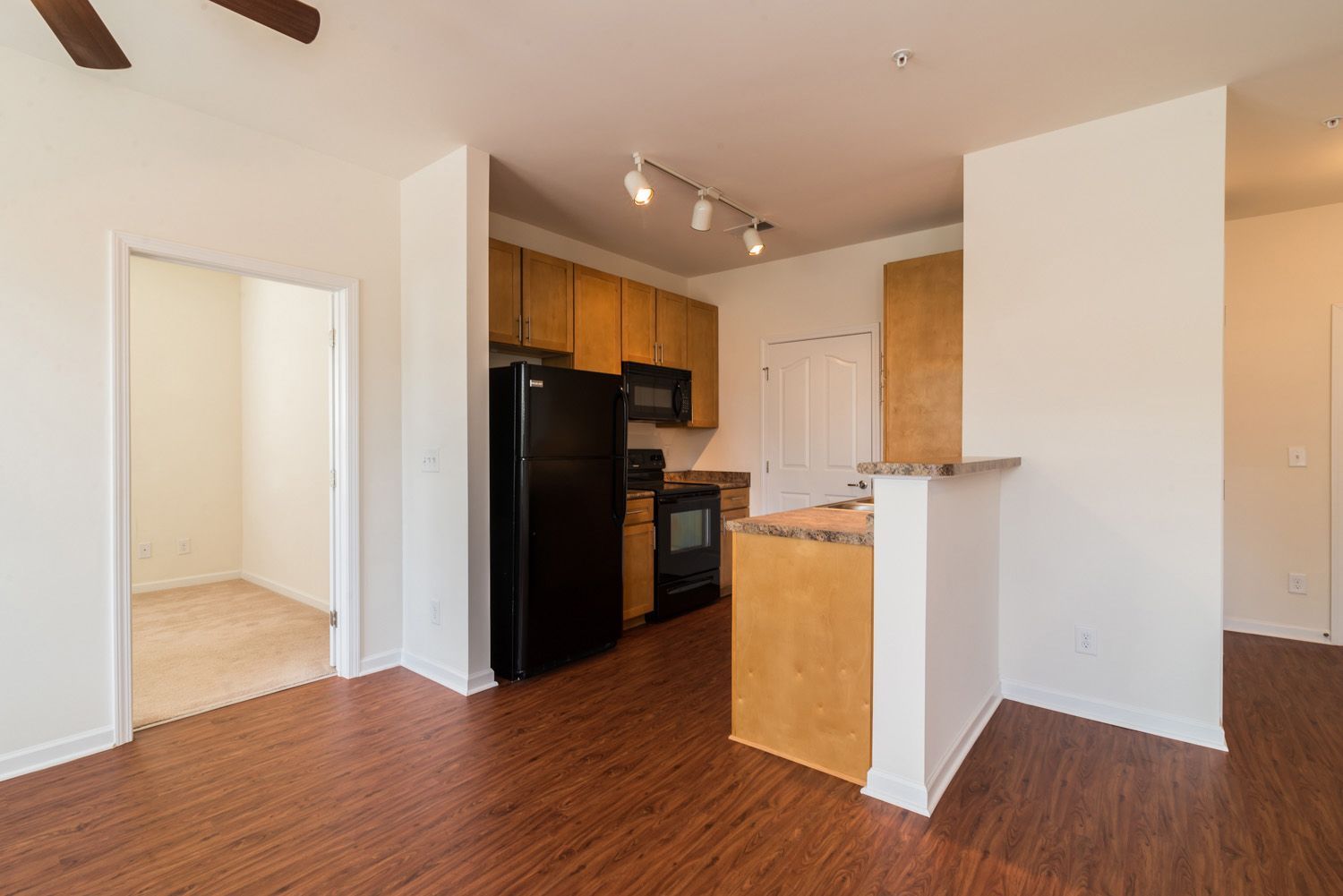 Kitchen view of an apartment with wooden cabinets and appliances