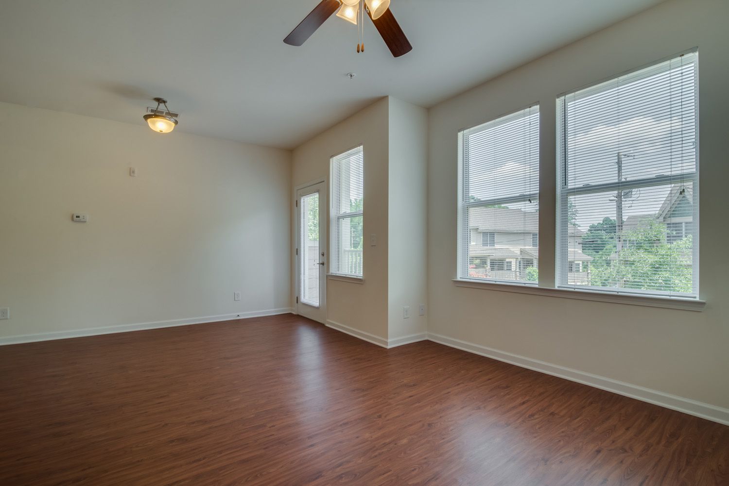 Interior view of an empty apartment living space with large windows.