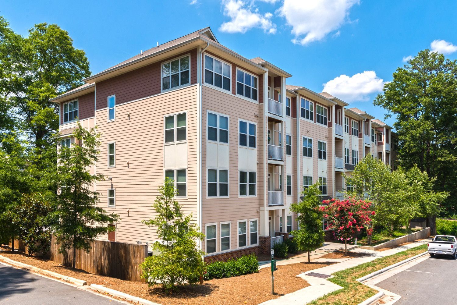 Exterior view of a multi-story apartment building with greenery.
