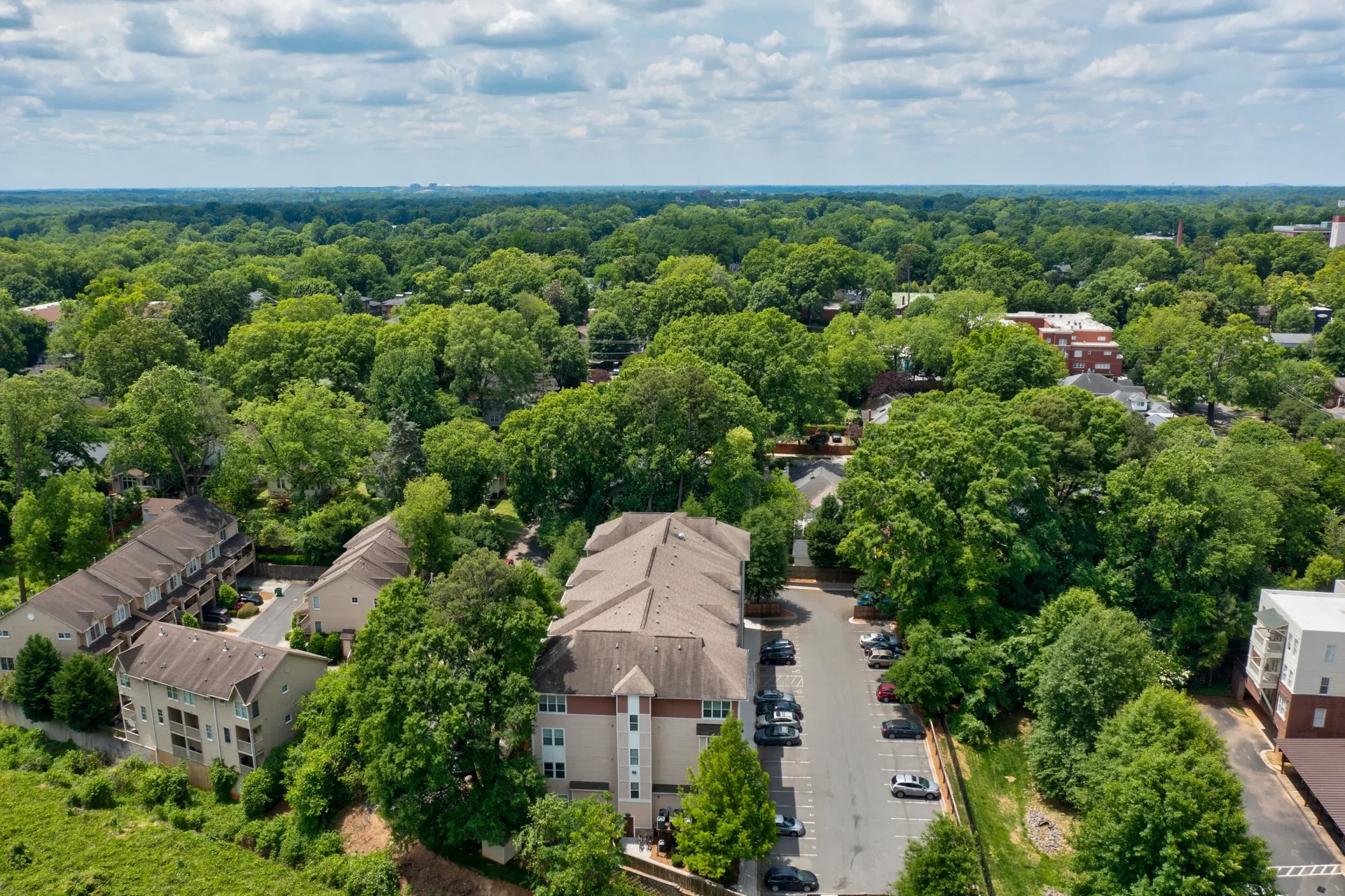 Aerial view of apartment buildings surrounded by lush greenery.