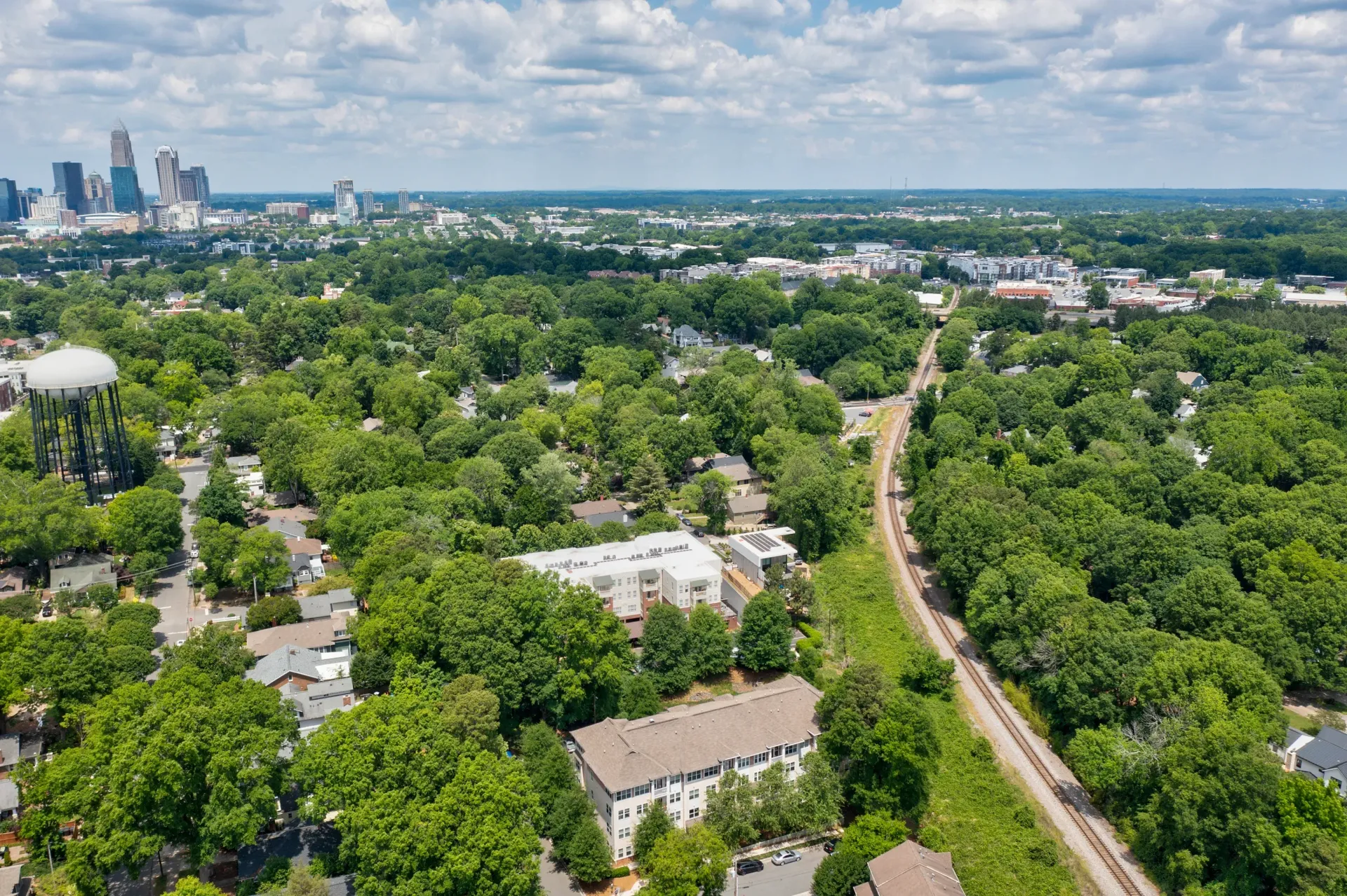 Aerial view of a green neighborhood with buildings and a water tower.