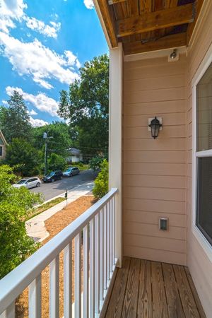 Woman shopping for flowers in a sunlit outdoor market, red carts filled with produce.