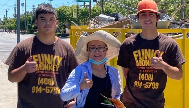 Three people with thumbs up, wearing brown 