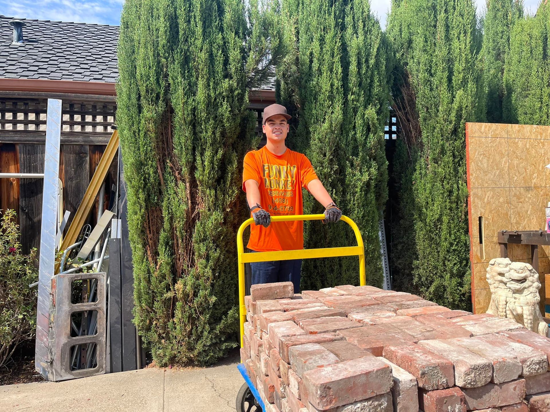 Patio with table, chairs, umbrella, and air conditioner next to a house under a clear sky.