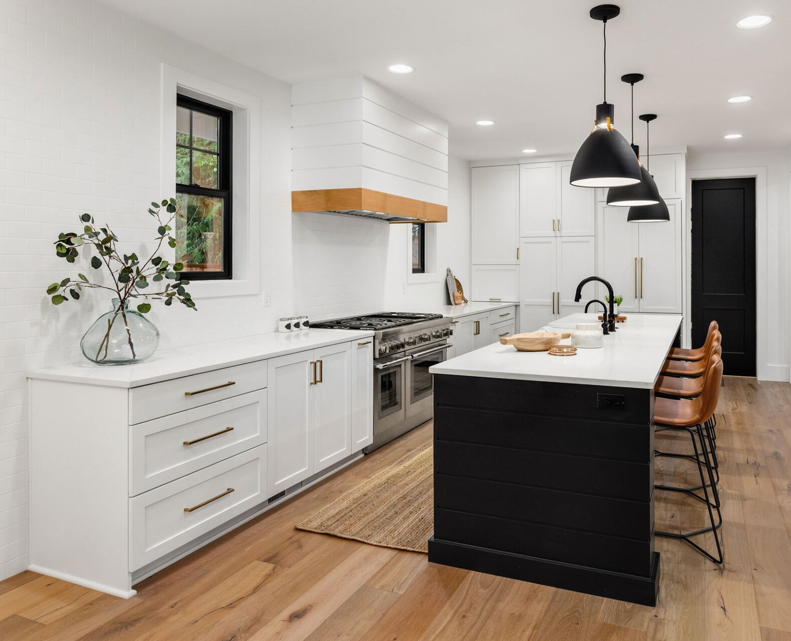 interior photo of a modern kitchen with white cabinets and stainless steel range