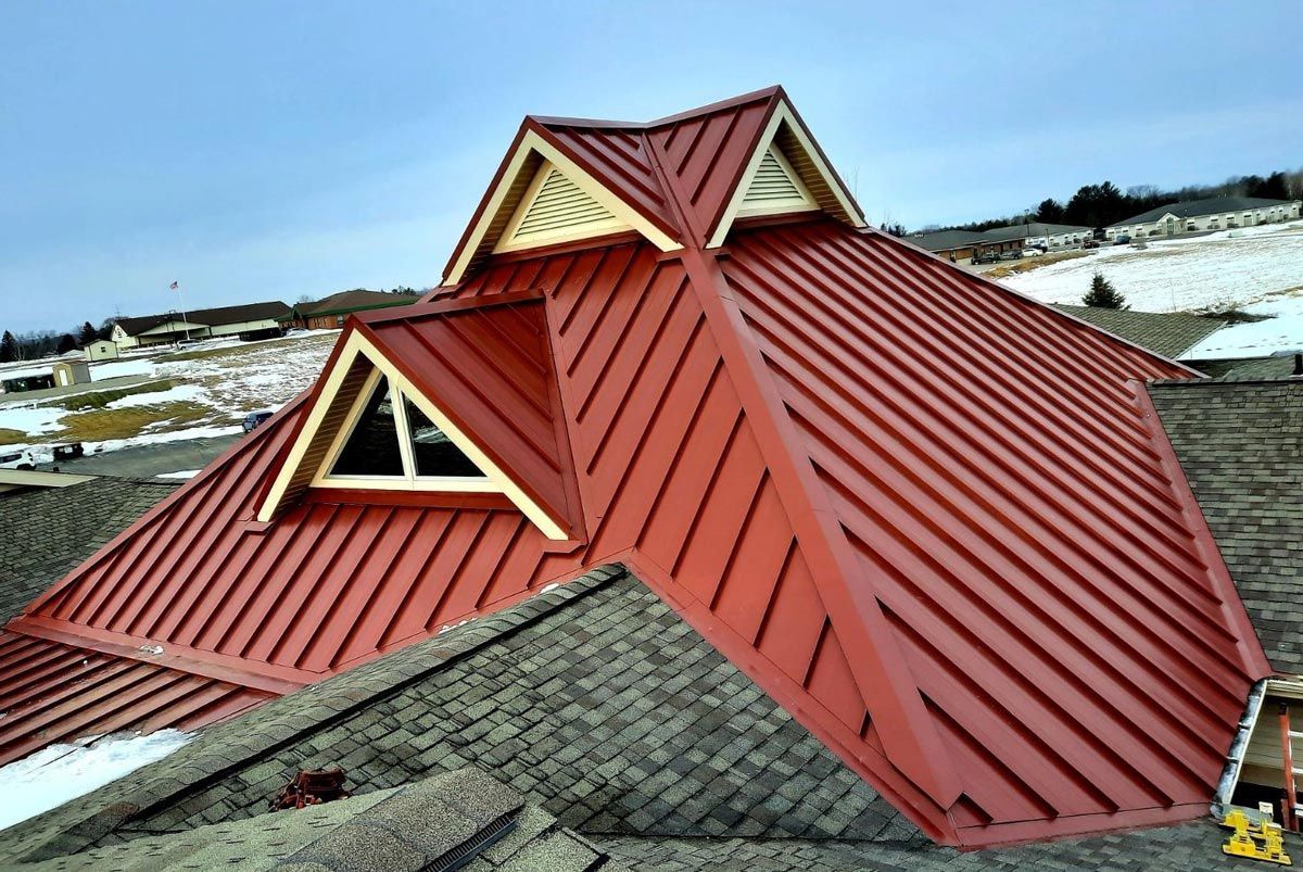 West Branch Michigan metal roofing project with Colonial Red standing seam panels, expertly installed by Northern Michigan metal roofers.