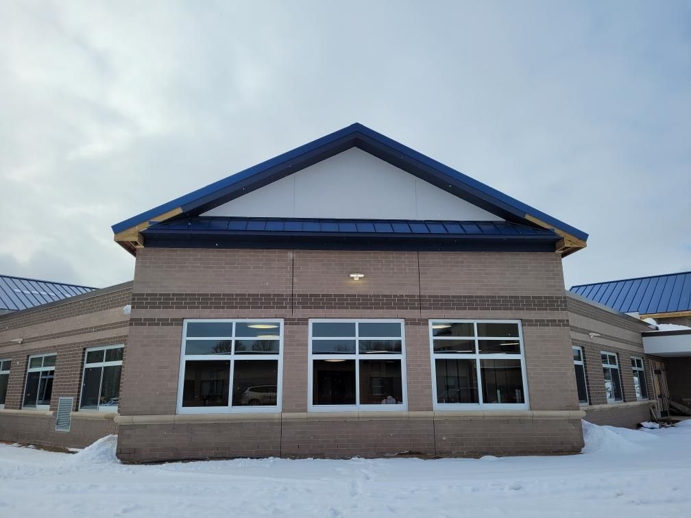 Roofing project featuring 24ga Regal Blue standing seam metal panels, expertly installed by Northern Michigan metal roofers.