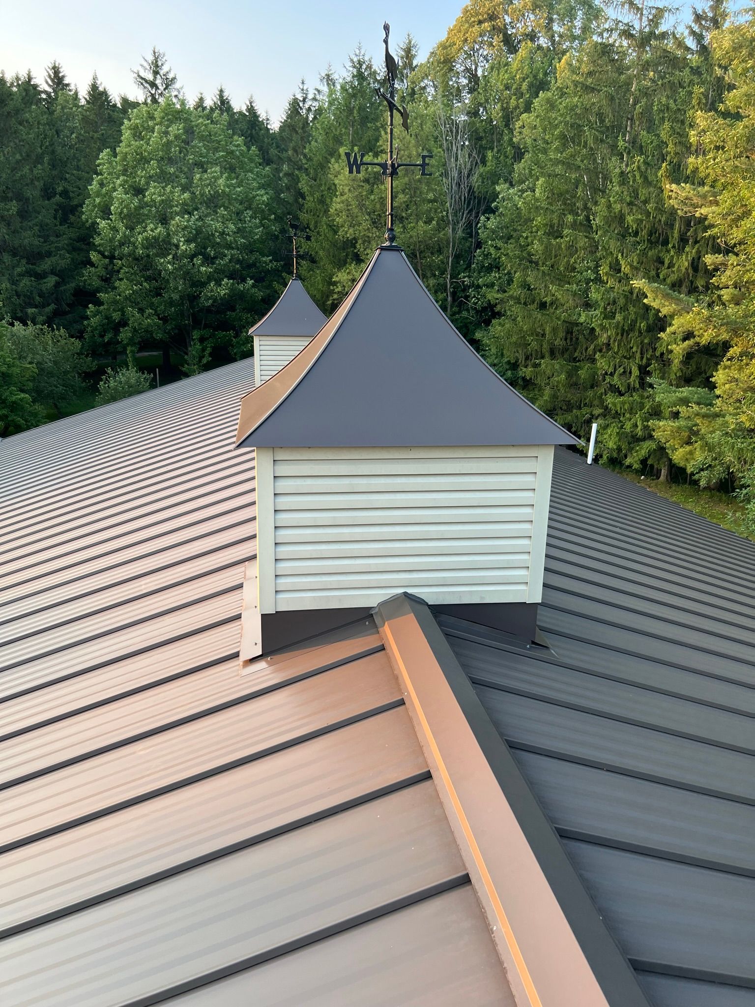 Close-up shot of the Burnished Slate metal roofing project on the Metamora horse arena by Riegle Metals. The image highlights the precise seams and smooth finish of the panels, showcasing the craftsmanship and durability of the installation.