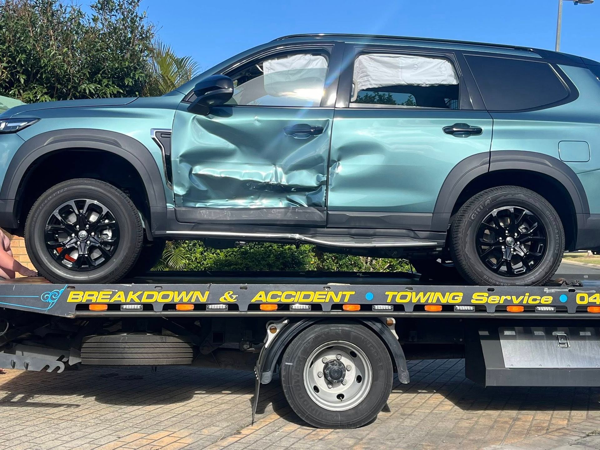 Damaged Teal SUV With Crushed Side on a Tow Truck Bed — A B & Forge Towing In Burpengary, QLD