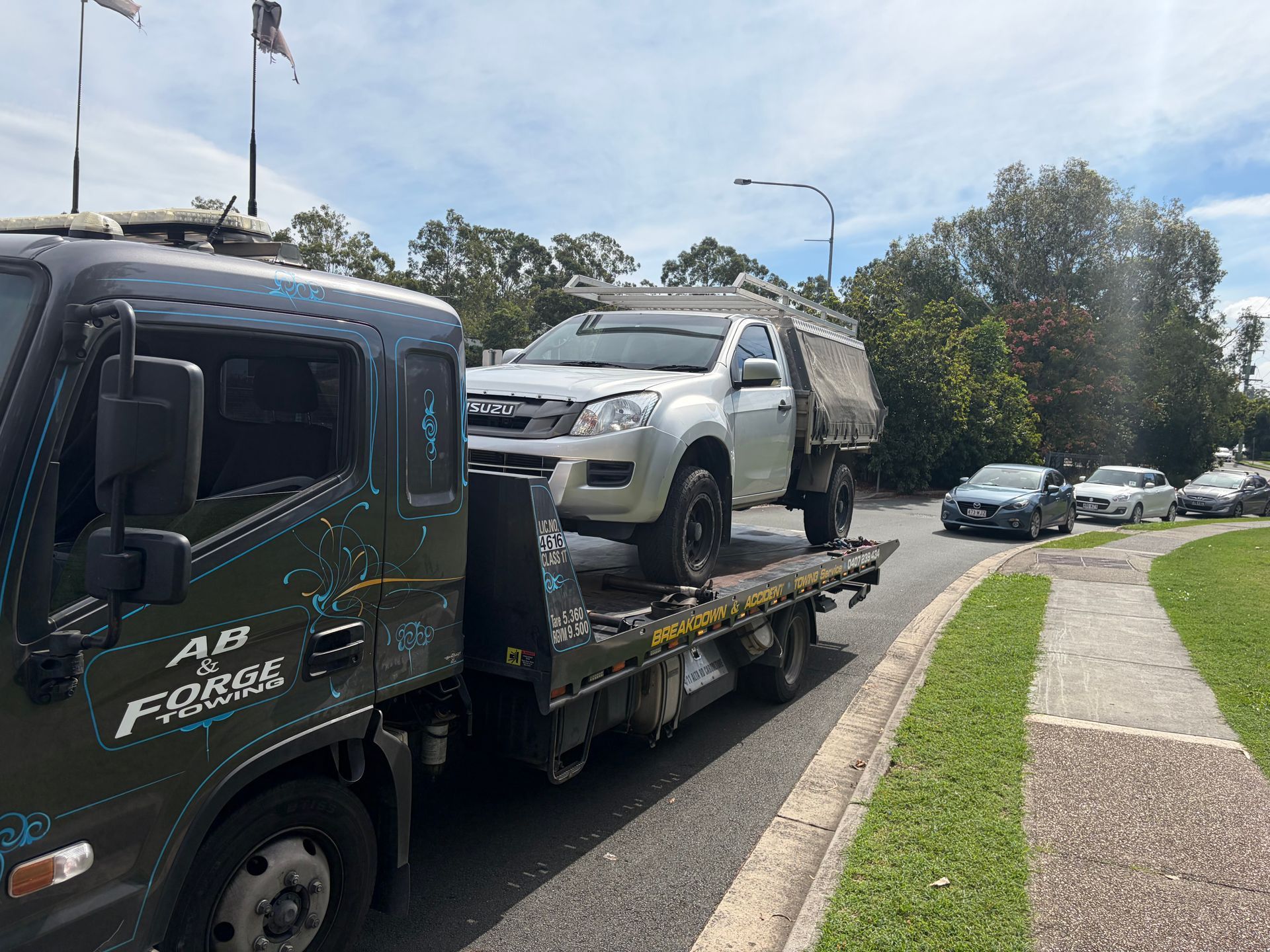 Tow truck carrying a silver pickup on a flatbed — A B & Forge Towing In Caboolture, QLD