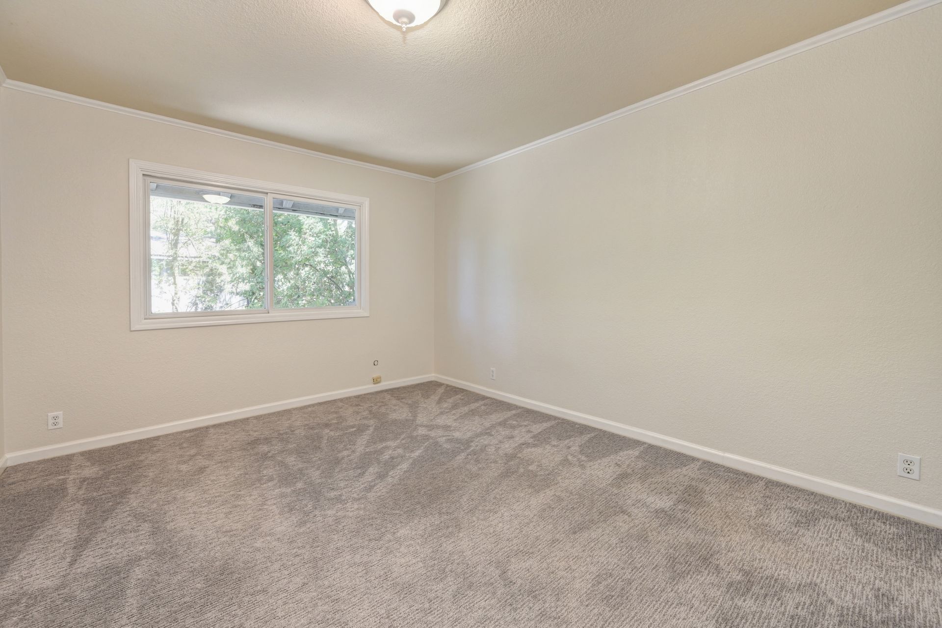 Empty bedroom with a carpeted floor and windows. Rich Cazneaux Real Estate Group Helps You Buy a House in East Sacramento, CA