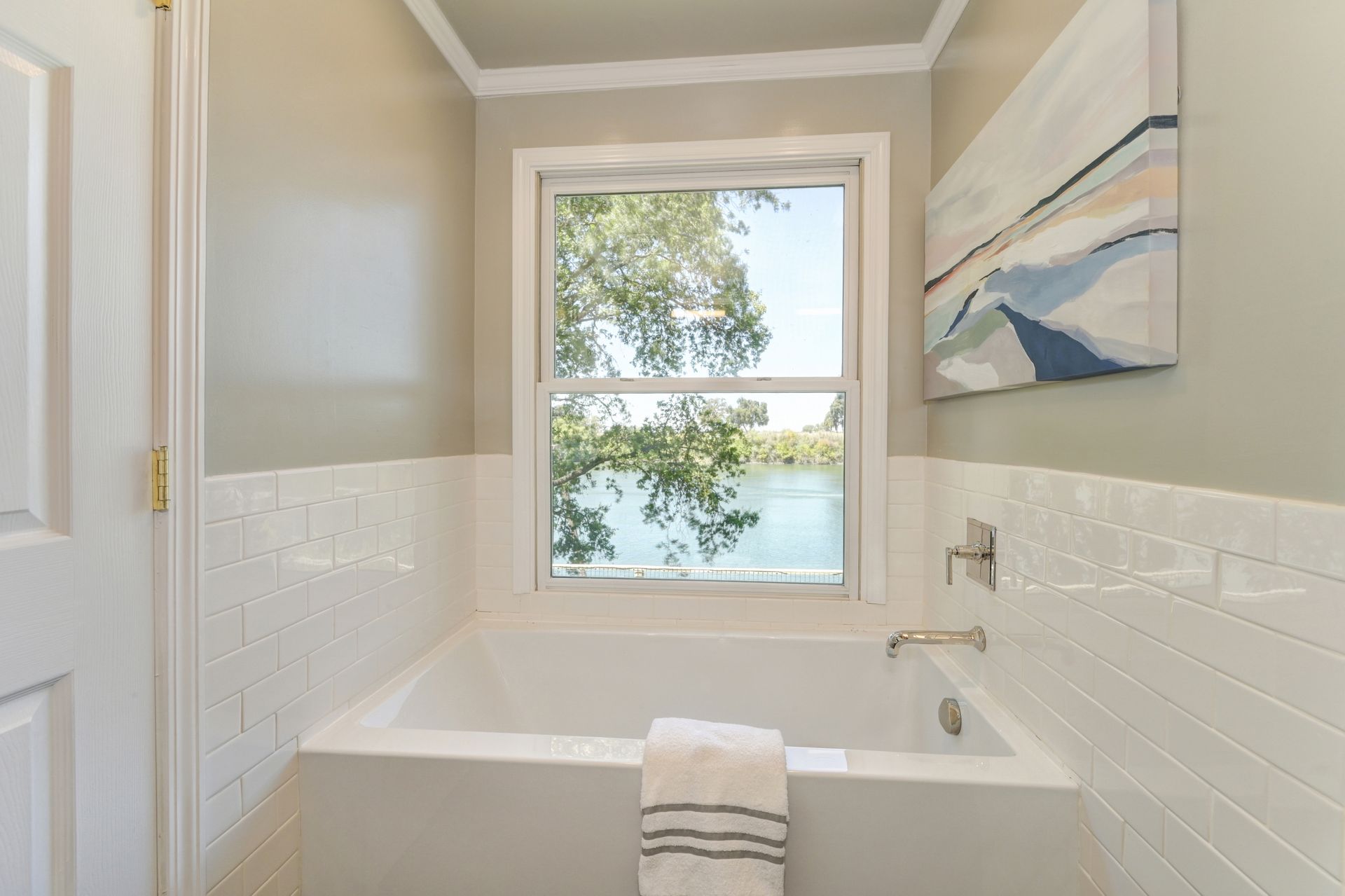 A bathroom with a tub and a window. Locate Your Dream Home with Best Listing Agent in East Sac, Rich Cazneaux