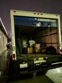 The open back of a truck is filled with neatly stacked boxes.