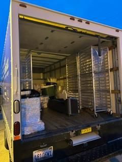 The open back of a truck is filled with neatly stacked boxes.