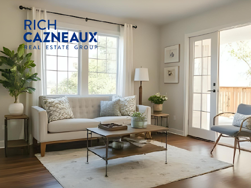 Living room with neutral-toned furniture, a large window, and access to an outdoor space. Light colo