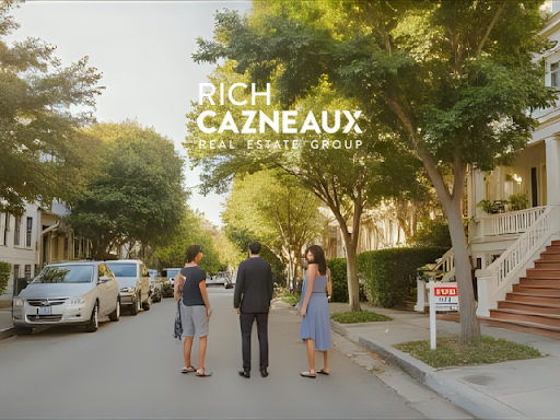 People looking at a house for sale with a real estate agent on a tree-lined street.