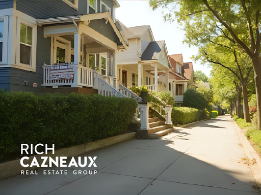 Row of houses with porches on a tree-lined street; Real Estate Group logo in the corner.