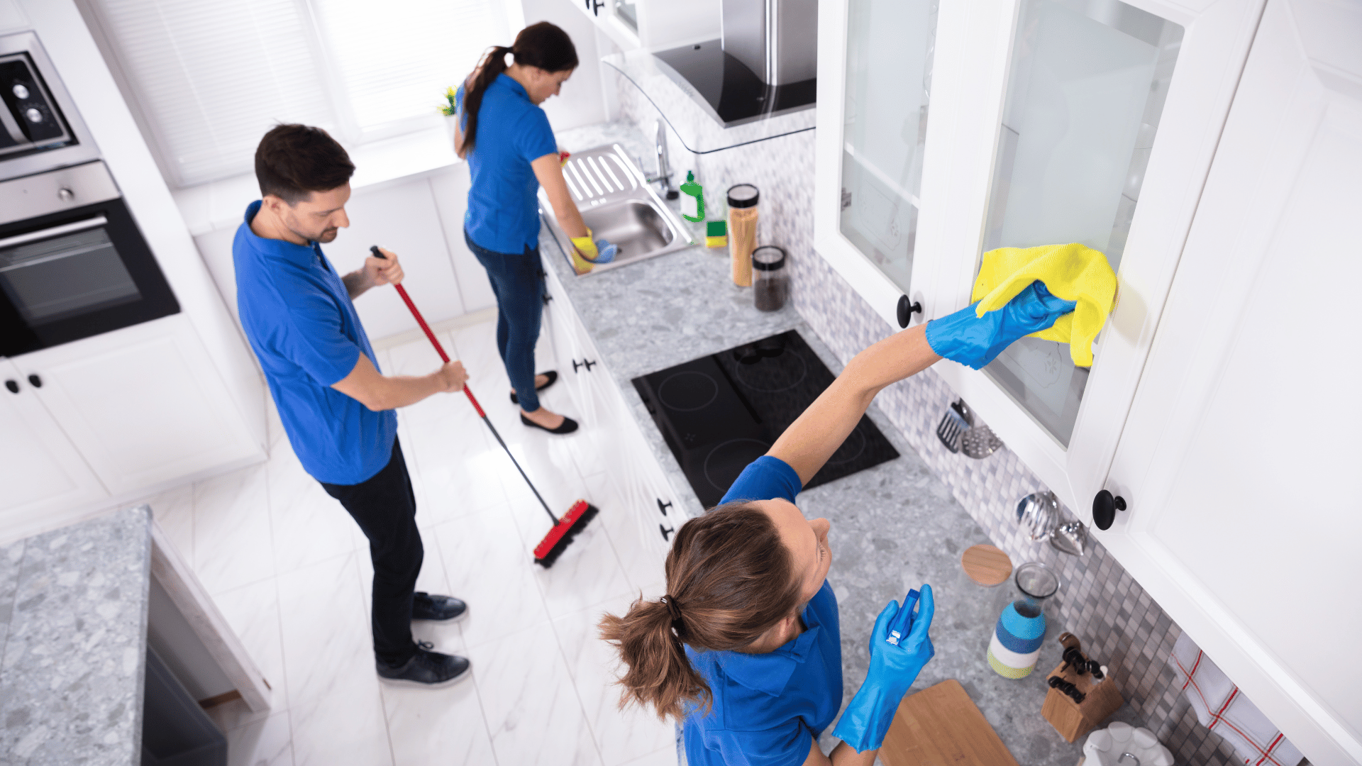 A group of people are cleaning a kitchen.