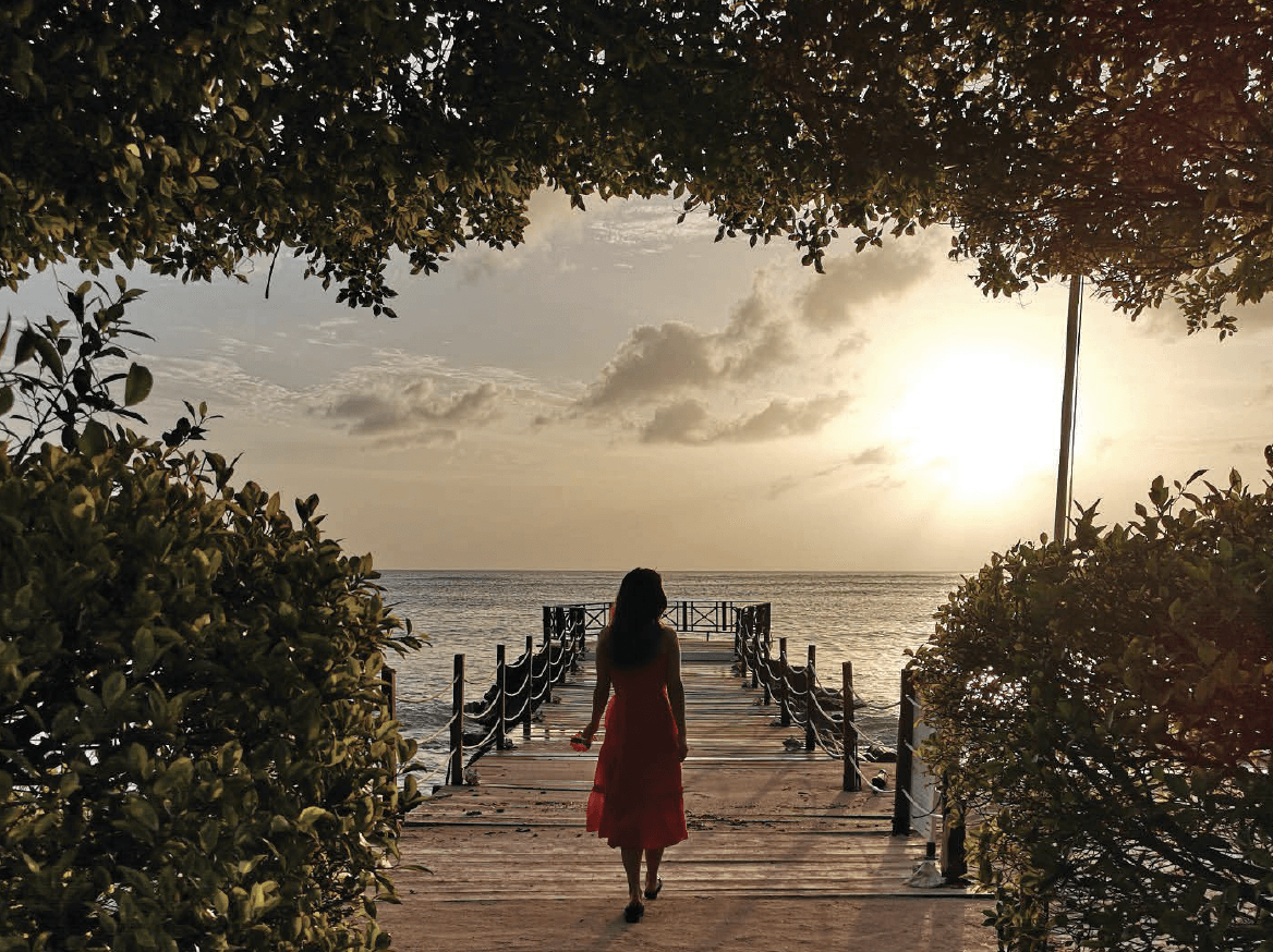 Girl walking down the boardwalk to the sea
